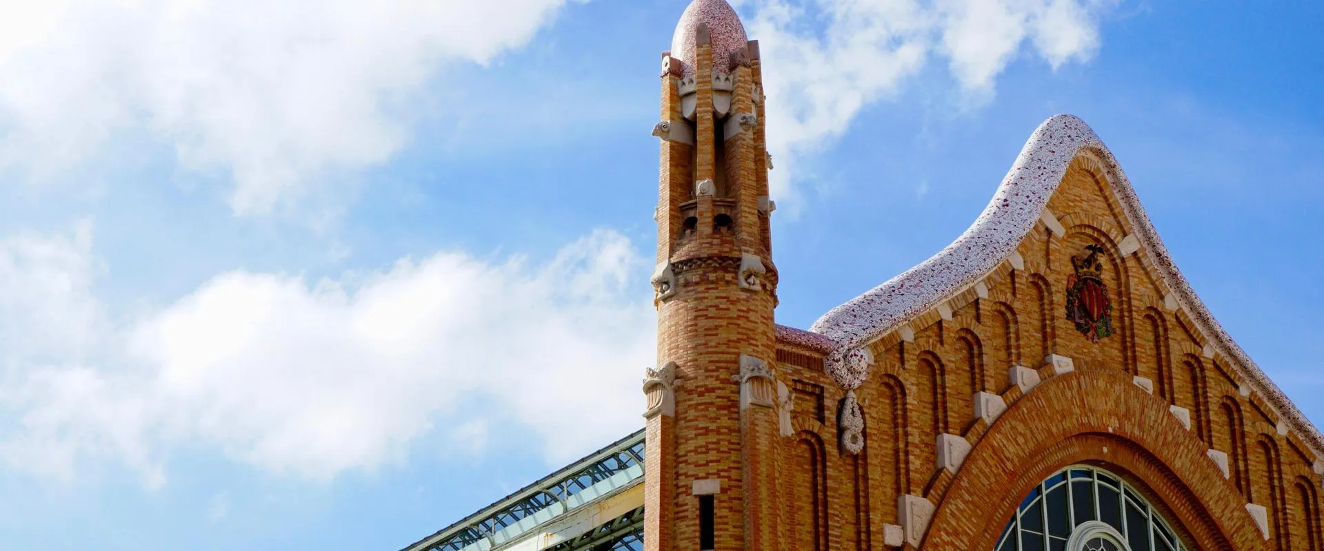 A tall building featuring a prominent clock tower at its top, set against a clear blue sky.